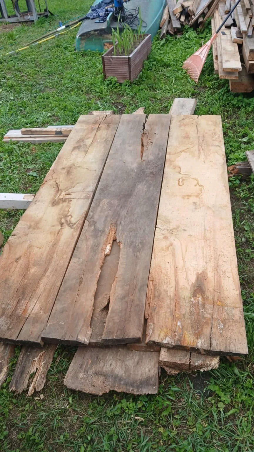 Sorted old oak boards with rustic cracks and damaged pieces.